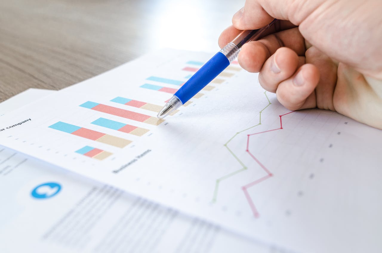 Person holding pen looking at charts